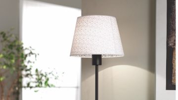 Una luminaria de mesa sobre un escritorio en el pasillo