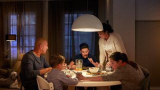 Grote LED hanglamp verlicht de eettafel van het gezin, creëert een warme sfeer voor avondmaaltijden en laat energiezuinige lichtoplossingen zien voor moderne huizen.