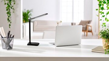 In een heldere witte kamer zien we een tafellamp en een laptop op een bureau