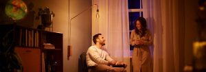 "luminária de chão com lâmpada LED de estilo vintage, criando um ambiente aconchegante para conversas noturnas de casais, exibindo iluminação ambiente com eficiência energética em uma sala de estar aconchegante."
