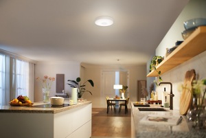Een grote keuken wordt helder verlicht door een plafondverlichting en een hanglamp