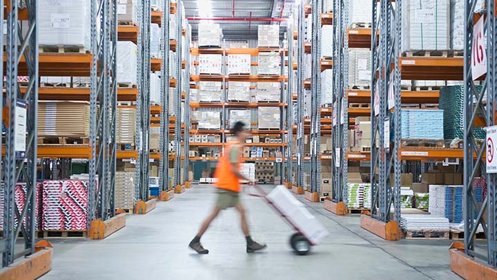 Medewerker in magazijn die een trolley gebruikt