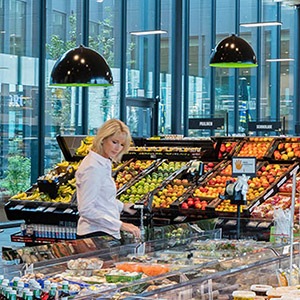 Vrouw die verse groenten en fruit koopt in de winkel
