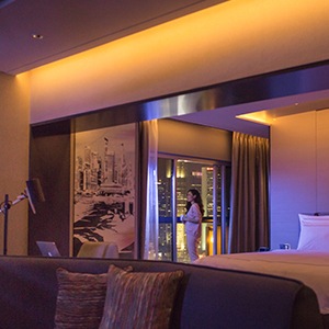 Vrouw aan het raam in een slecht verlichte hotelkamer