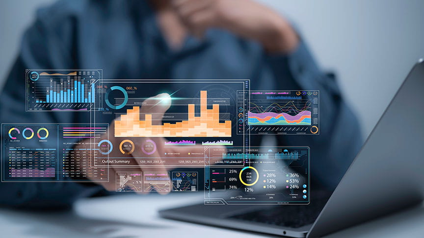 Hand pointing at charts and data on screen