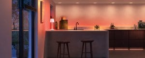 Un plan de travail de cuisine éclairé par des tons chauds orange et blancs provenant d’un éclairage intelligent.