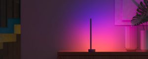 A Philips Hue Signe gradient table lamp washes a wall in purple and pink tones of smart light.
