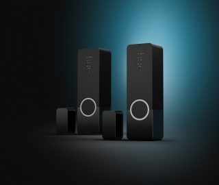 Deux capteurs de contact de sécurité Hue Secure noirs sur un fond noir et bleu. 