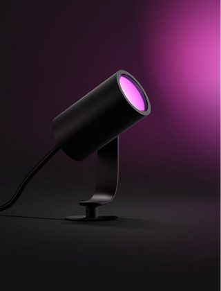 Un spot noir Philips Hue Lily diffusant une lumière rose. 
