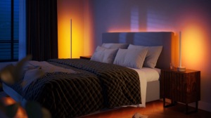 Bedroom with wall-wash lighting casting a soft ambient glow in warm tones, highlighting both the bed and bedside tables