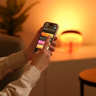 Primer plano de alguien ajustando sus luces con la Hue app.