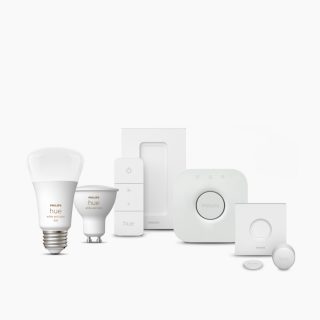 Collection of smart bulbs, remote controls, bridge device, and sensors in white color, with visible product labels and buttons.