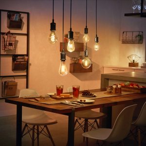 Hue pendant cords with Hue filament bulbs above dining table 