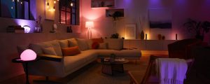 Modern living room with smart lights casting soft ambient glow in various colors on walls, furniture, and decor items.