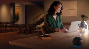 Person working on a laptop at a desk in a modern living space, illuminated by a white LED light bar on the tabletop.