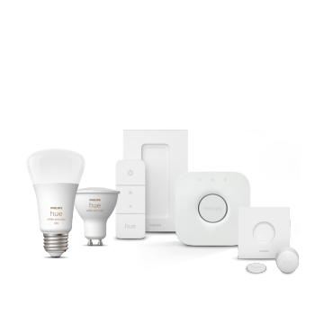 A collection of smart bulbs, a remote control, a hub, a sensor, and mounting accessories in white are displayed on a plain background.