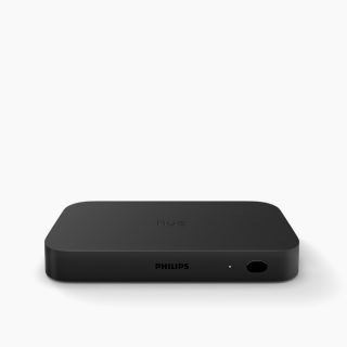 Rectangular black sync box with matte finish, compact shape, visible LED indicator, port, and embossed ""hue"" on top.