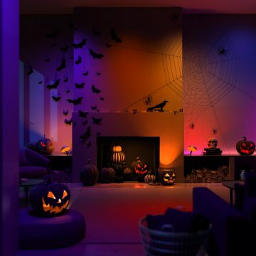 Farbfähige smarte Philips Hue Lampen in einem mit leuchtend orangenen Kürbissen dekorierten Halloween-Wohnzimmer