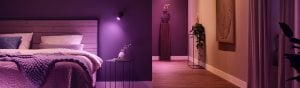 Bedroom with soft ambient purple lighting, wooden headboard, cosy bedding, side table and hallway with decorative accents.