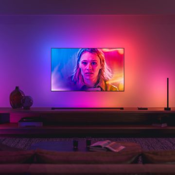 LG TV hanging on wall in living room surrounded by colorful lights