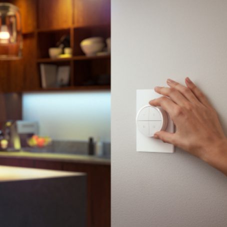 Hand adjusting dimmer switch next to kitchen