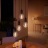 A cluster of four pendant lights fitted with Philips Hue Filament bulbs glowing in warm white light.