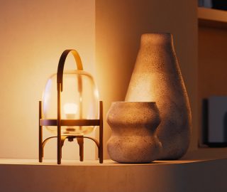 A glass table lamp fitted with a Philips Hue smart bulb glowing in a warm tone of white light. 