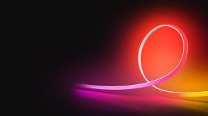 An OmniGlow strip light glowing in pink, red, and yellow light against a black background. 