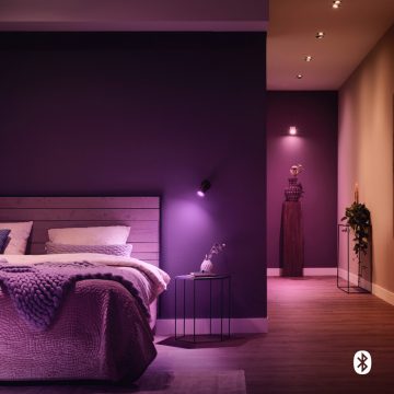 Bedroom with smart lights on the walls and ceiling set to purple