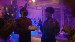 Group of people joyfully celebrating at a lively party under vibrant mood lighting that enhances the festive and energetic atmosphere.