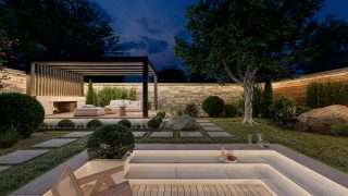 A backyard and patio seating area lit with outdoor smart lighting, including outdoor strip lights glowing in warm white tones of light.