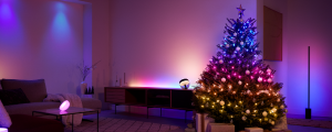 Living room with a decorated Christmas tree and smart lights creating a soft ambient glow in various colors across the space.