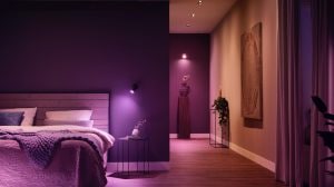 Bedroom and hallway illuminated by smart lighting, creating a soft ambient glow with purple and warm tones on walls and decor.