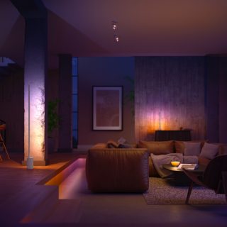 Modern living room with soft ambient glow from smart lighting, highlighting seating area and architectural features in warm tones.