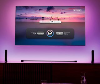 A TV screen setup with entertainment lighting and showing the Philips Hue Sync TV app.