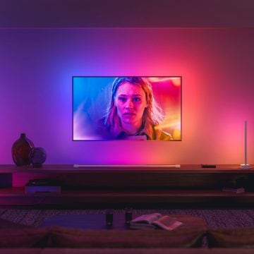 LG TV hanging on wall in living room surrounded by colorful lights 