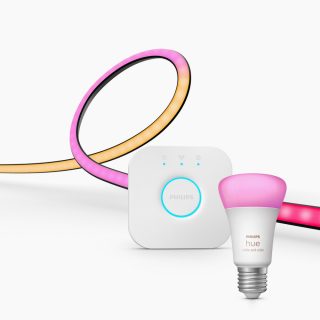 A set of smart lighting products including a multicolored light strip, a white hub device, and a white bulb with a pink glow.