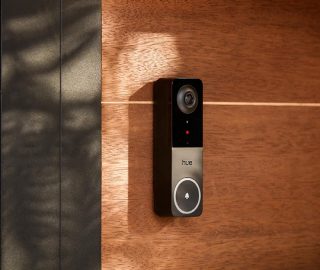 A black Hue Doorbell camera mounted on a wall. 