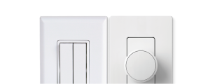 Two white smart wall switches, one with dual rectangular buttons and one with a round dial, both with a matte finish.