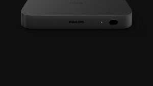 Black rectangular sync box with matte finish, front-facing button, indicator light, and visible ""PHILIPS"" and ""hue"" text.