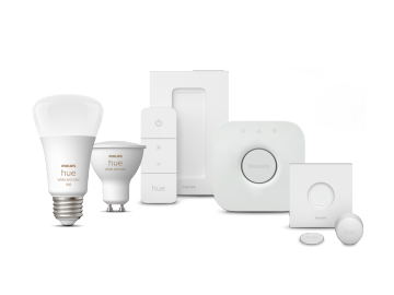 A set of smart lighting products including white and color LED bulbs, a remote control, a hub, and motion sensors, all in white.
