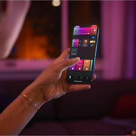 Hand holding mobile device with Hue app  