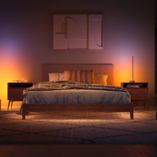 Bedroom with modern wall art and soft ambient lighting casting a warm glow on the bed and nightstands.