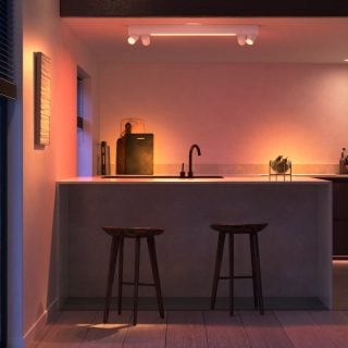 White smart ceiling light fixture mounted above kitchen counter, illuminating sink and countertop with adjustable colored lighting.
