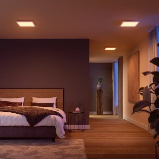 Square ceiling smart lights installed in a bedroom, emitting soft illumination over the bed and hallway, enhancing visibility.