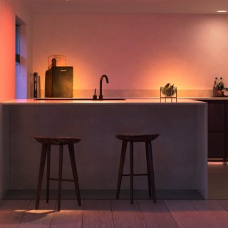 Smart lighting installed under the kitchen counter and backsplash, casting colored illumination onto countertop and wall surfaces.