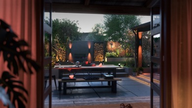 Outdoor patio space with a collection of smart lights creating a soft ambient glow among garden furniture, plants, and outdoor decor.