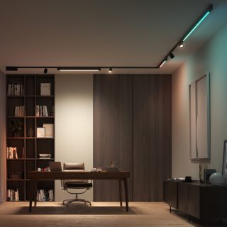 Ceiling-mounted track lighting system with adjustable fixtures and colored light bars illuminating a modern office workspace.