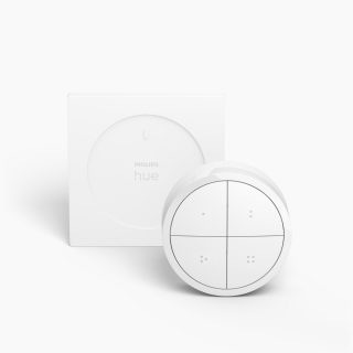 White smart lighting remote control with a circular shape, four buttons, matte finish, and a square wall mount accessory.