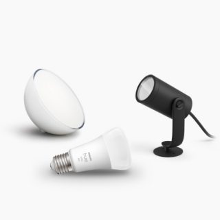 A collection of smart lighting products including a white LED bulb, a round light, and a black spotlight on a plain background.